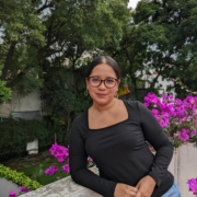 Sue Montoya in front of purple flowers