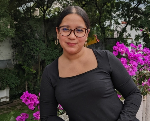 Sue Montoya in front of purple flowers