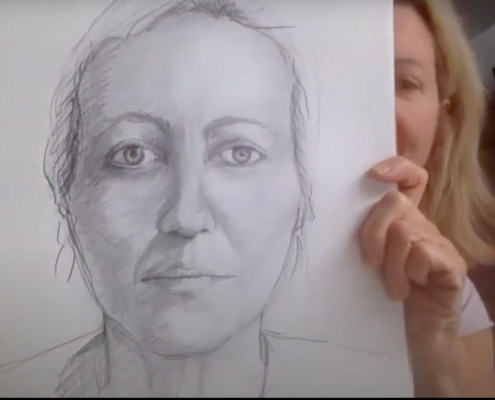 Person holding up a drawing of a person