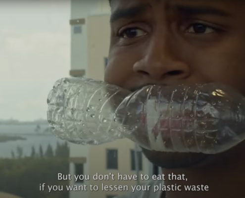 Person with empty plastic bottle in their mouth