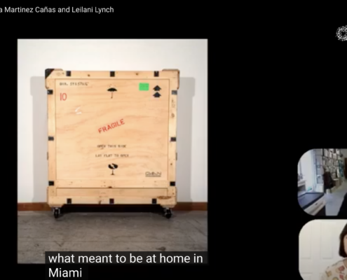 A screengrab featuring a wooden crate and two rounded rectangles in the bottom right with a person in each shape