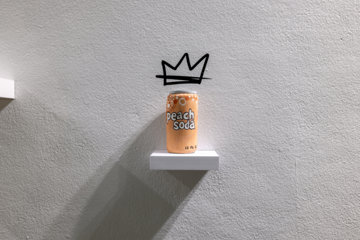 Detail view of Friday's artwork of a can of soda with a crown in the vitrine