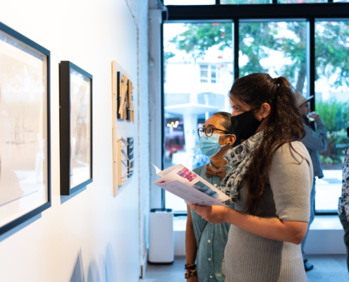 People standing in front of artwork on a wall admiring it