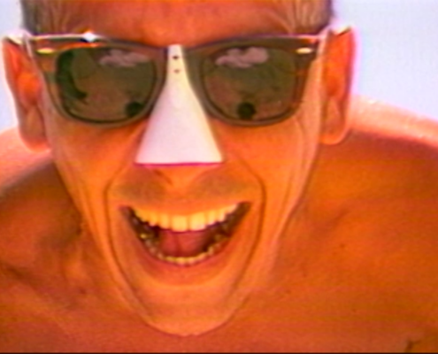A person wearing sunglasses featuring a white nose covering with mouth open similar to mid laugh
