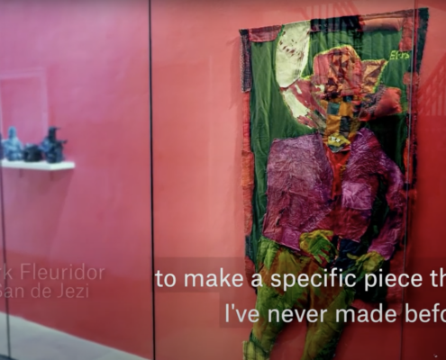 Viewing Mark Fleuridor's work inside a vitrine against a red background