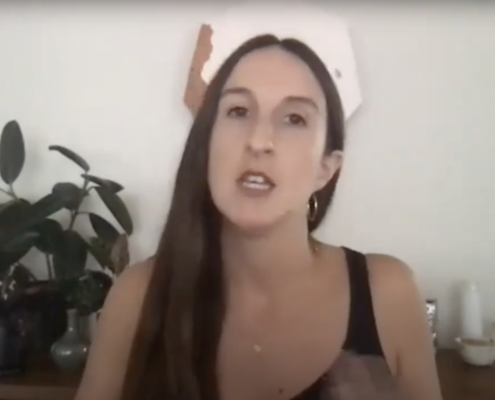 Diana Nawi mid sentence against a white wall with a plant behind her
