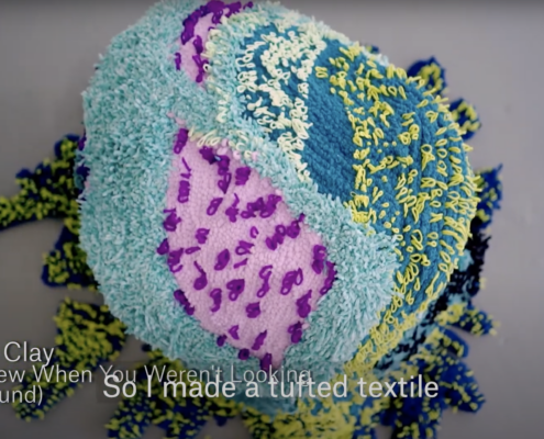 Round fiber sculpture in blue, purple and pink. The sculpture looks like an organism
